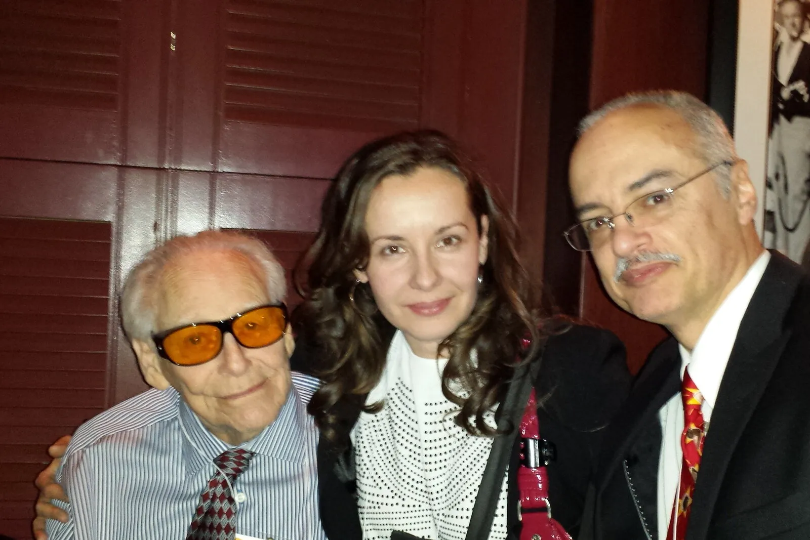 Dr. Ortiz, his wife, and Dr. Richard Woodcock posing together at a reception.